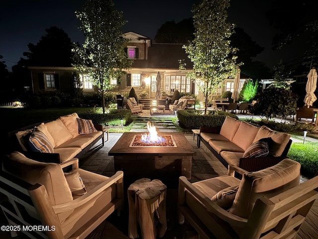 patio at twilight with an outdoor living space with a fire pit