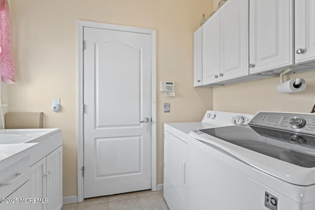 laundry room featuring light tile patterned floors, washing machine and clothes dryer, cabinet space, and baseboards