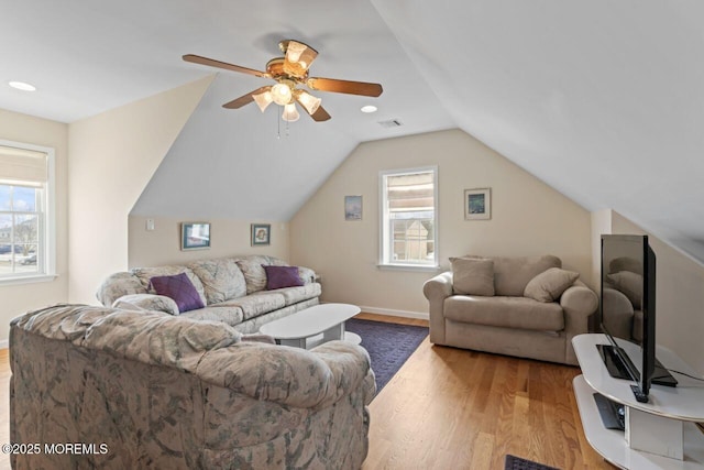 living area featuring lofted ceiling, light wood-type flooring, a ceiling fan, and baseboards