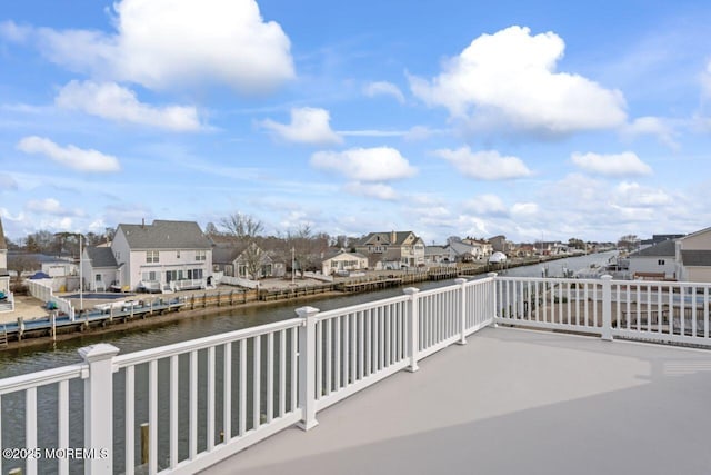 balcony with a patio, a water view, and a residential view