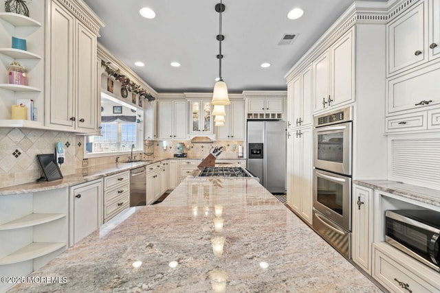 kitchen featuring appliances with stainless steel finishes, pendant lighting, light stone counters, and open shelves