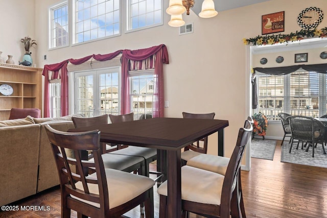 dining room with dark wood-style floors, plenty of natural light, visible vents, and french doors