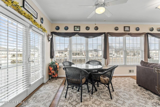 dining area featuring a ceiling fan, baseboards, visible vents, and crown molding