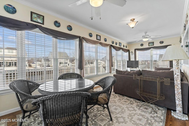 interior space with ornamental molding, wood finished floors, and a ceiling fan