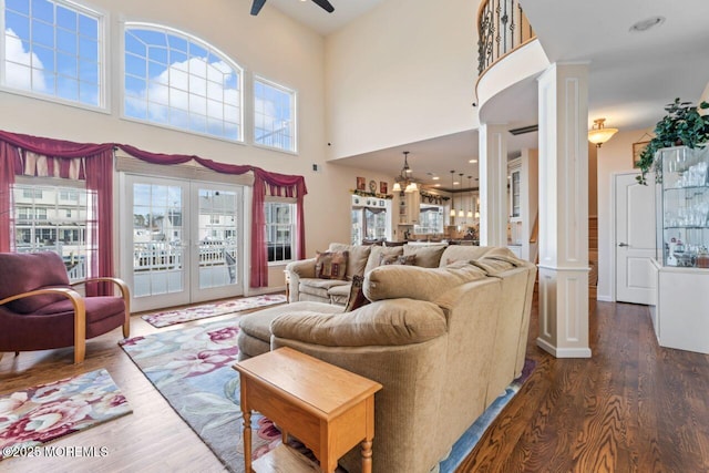 living room featuring dark wood-style flooring, decorative columns, french doors, and ceiling fan