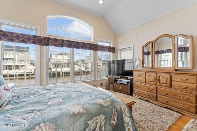 bedroom with ornamental molding, vaulted ceiling, and wood finished floors