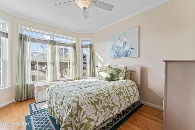 bedroom with light wood finished floors, multiple windows, and ornamental molding