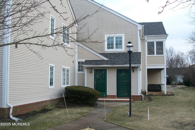 exterior space with a front lawn and roof with shingles