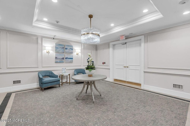 sitting room featuring recessed lighting, visible vents, a raised ceiling, and a decorative wall