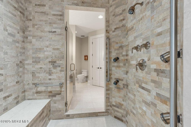 full bathroom featuring a shower stall and toilet