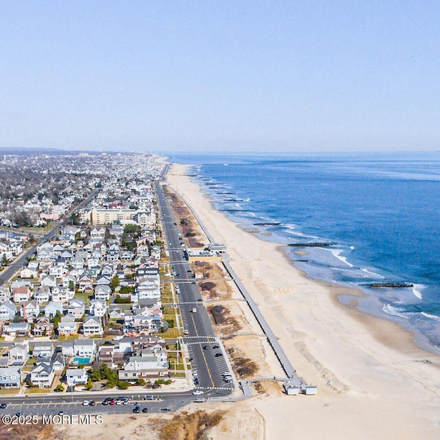 bird's eye view featuring a water view and a beach view