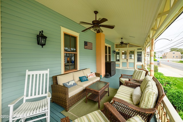 wooden terrace featuring ceiling fan, an outdoor hangout area, and covered porch