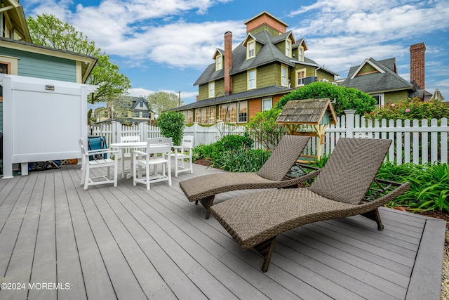 deck featuring outdoor dining area and fence