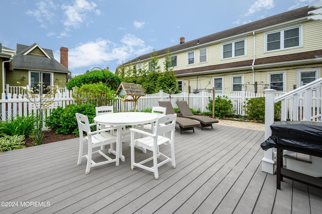 deck with outdoor dining area and fence