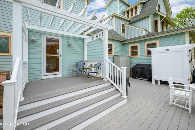 wooden deck with grilling area and a pergola