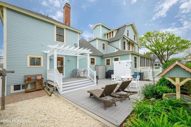 rear view of property with a shingled roof, a chimney, fence, a deck, and a pergola