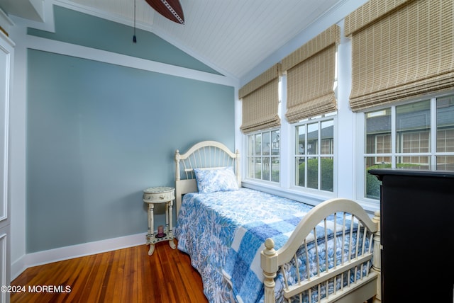 bedroom featuring vaulted ceiling, ornamental molding, wood finished floors, and baseboards