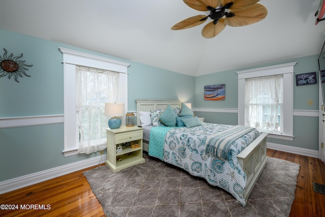 bedroom featuring dark wood-type flooring, lofted ceiling, and multiple windows