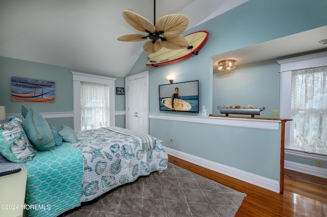 bedroom with lofted ceiling, ceiling fan, wood finished floors, and baseboards