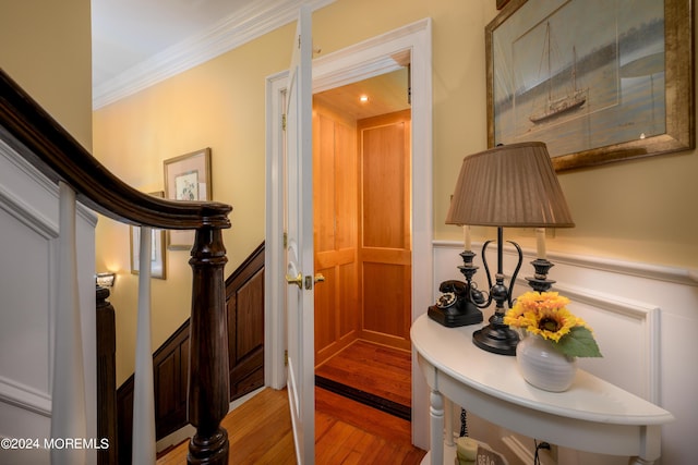 hall featuring light wood-type flooring, stairs, and crown molding