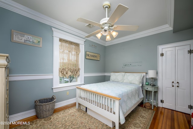 bedroom with crown molding, visible vents, ceiling fan, wood finished floors, and baseboards