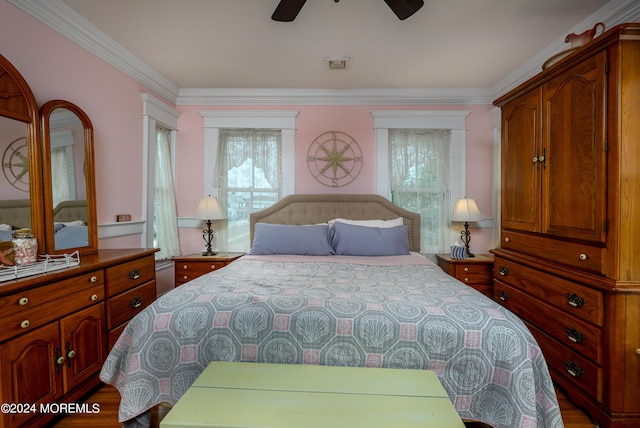 bedroom with ceiling fan, visible vents, and crown molding