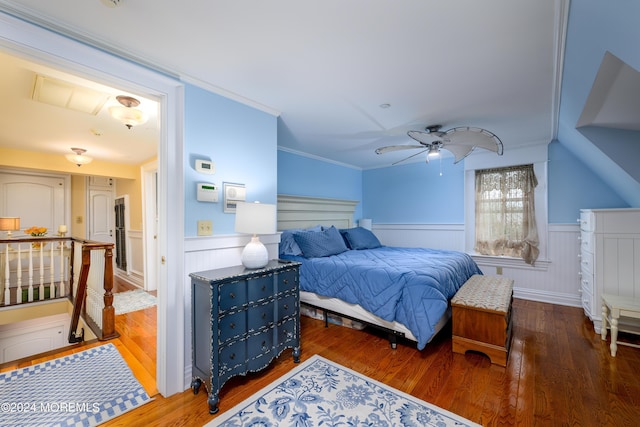 bedroom featuring ceiling fan, ornamental molding, dark wood finished floors, and wainscoting