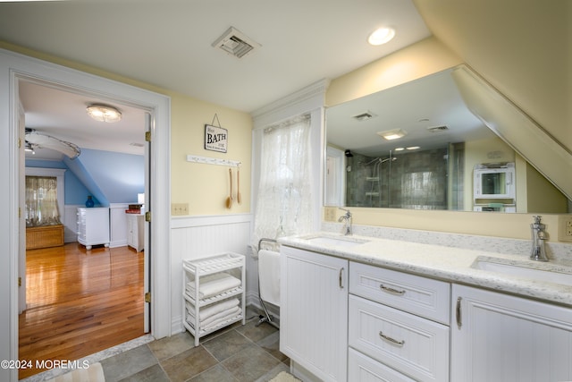 bathroom featuring wainscoting, visible vents, a sink, and a shower stall