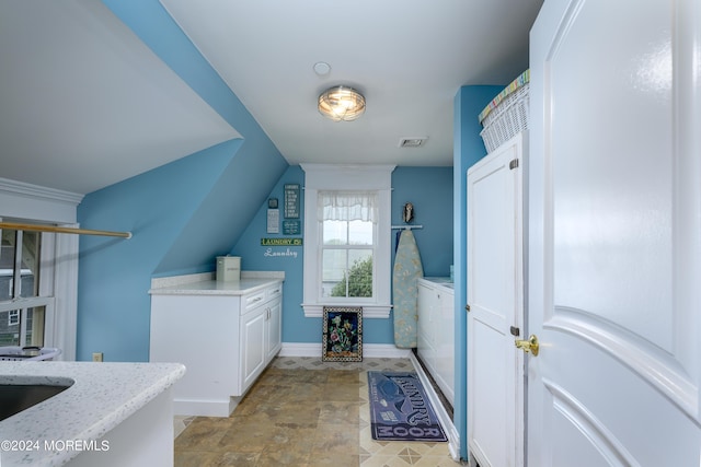 bathroom featuring washer and dryer, visible vents, and baseboards