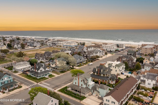 aerial view at dusk with a residential view and a water view