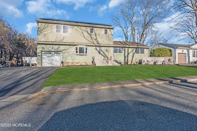 view of front of property with driveway, a garage, a front lawn, and solar panels