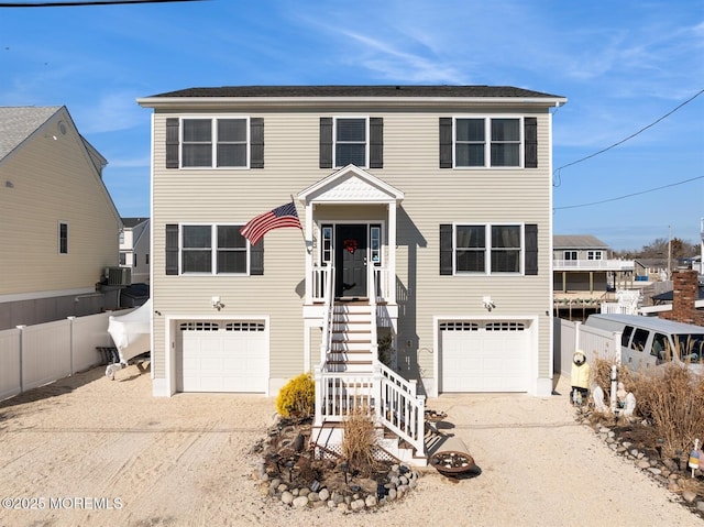 view of front of home featuring driveway, an attached garage, and fence