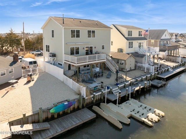 rear view of property featuring a residential view, a water view, a fenced backyard, and central air condition unit