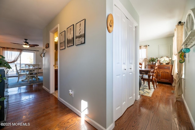 hallway featuring baseboards and wood finished floors