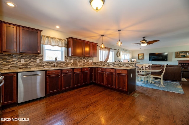 kitchen featuring dark wood-style flooring, a sink, open floor plan, hanging light fixtures, and stainless steel dishwasher