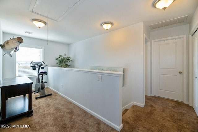 corridor featuring attic access, visible vents, carpet flooring, and an upstairs landing