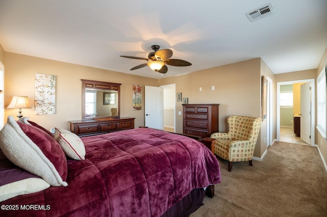 bedroom with a ceiling fan, visible vents, light carpet, and multiple windows