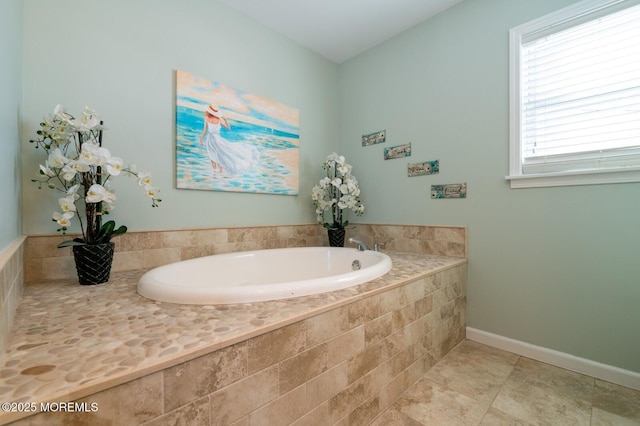 bathroom featuring tile patterned flooring, a garden tub, and baseboards