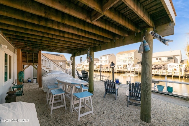 view of patio / terrace with stairs, a water view, and a residential view