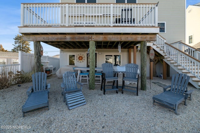 back of property featuring fence, stairway, and a deck