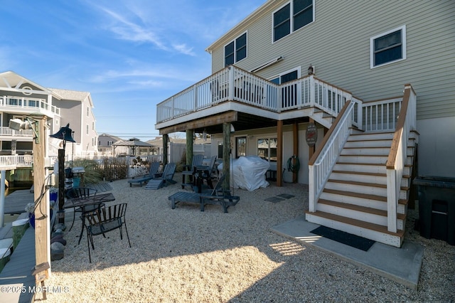 rear view of house with stairs and a deck