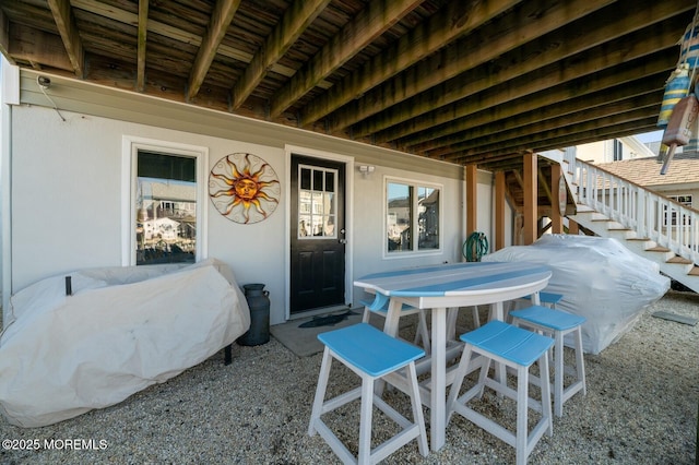 view of patio / terrace featuring stairs, outdoor dining area, and area for grilling