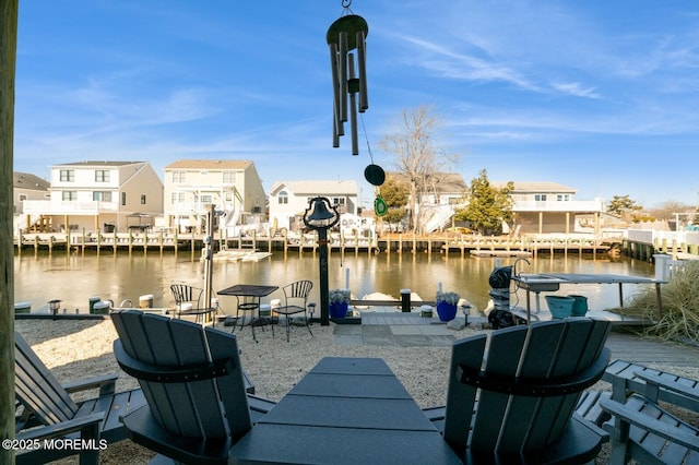 view of patio / terrace with a boat dock, a water view, and a residential view