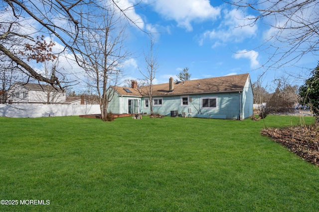 rear view of property with a lawn and a chimney