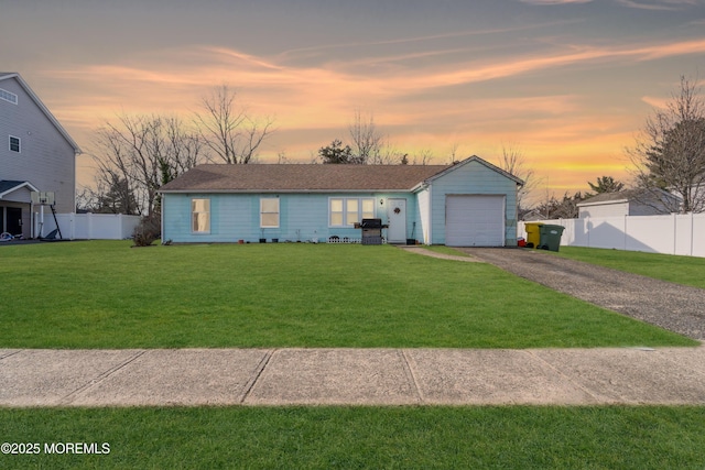 view of front facade with a garage, driveway, a front yard, and fence