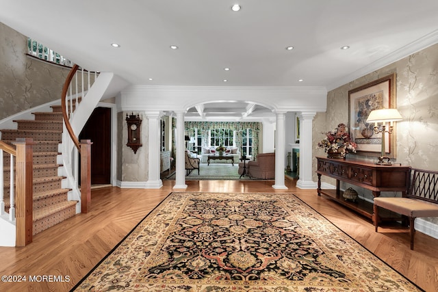 foyer with arched walkways, recessed lighting, ornamental molding, stairway, and decorative columns