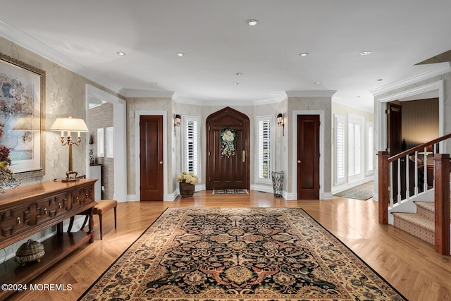 entrance foyer featuring recessed lighting, light wood-style flooring, ornamental molding, baseboards, and stairs