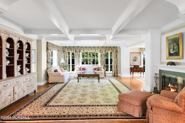 interior space featuring coffered ceiling, beamed ceiling, and a glass covered fireplace