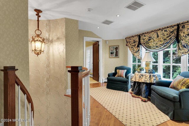 living room featuring wallpapered walls, visible vents, and wood finished floors