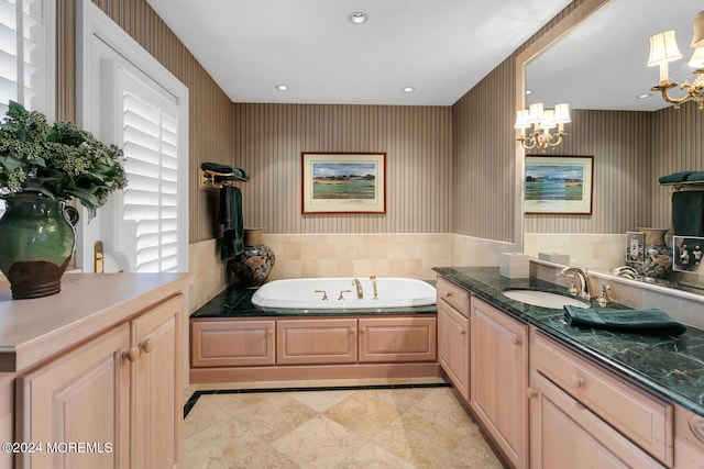 full bath with wallpapered walls, vanity, a chandelier, a bath, and recessed lighting